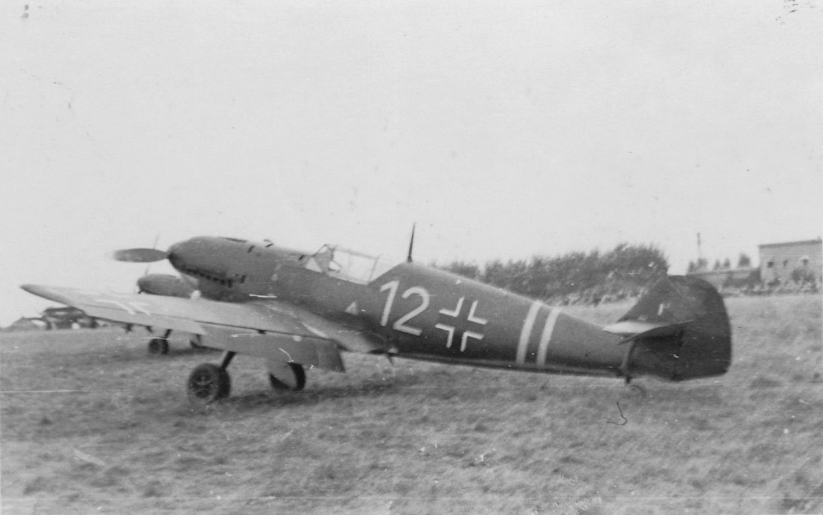 Bf 109 D-1, Zerstörergeschwader 2, I. Gruppe, 3. Staffel, Deutschland, gelbe 12, Beachte den einzelnen Abschussbalken an der Seitenflosse.

Das Hakenkreuz, …