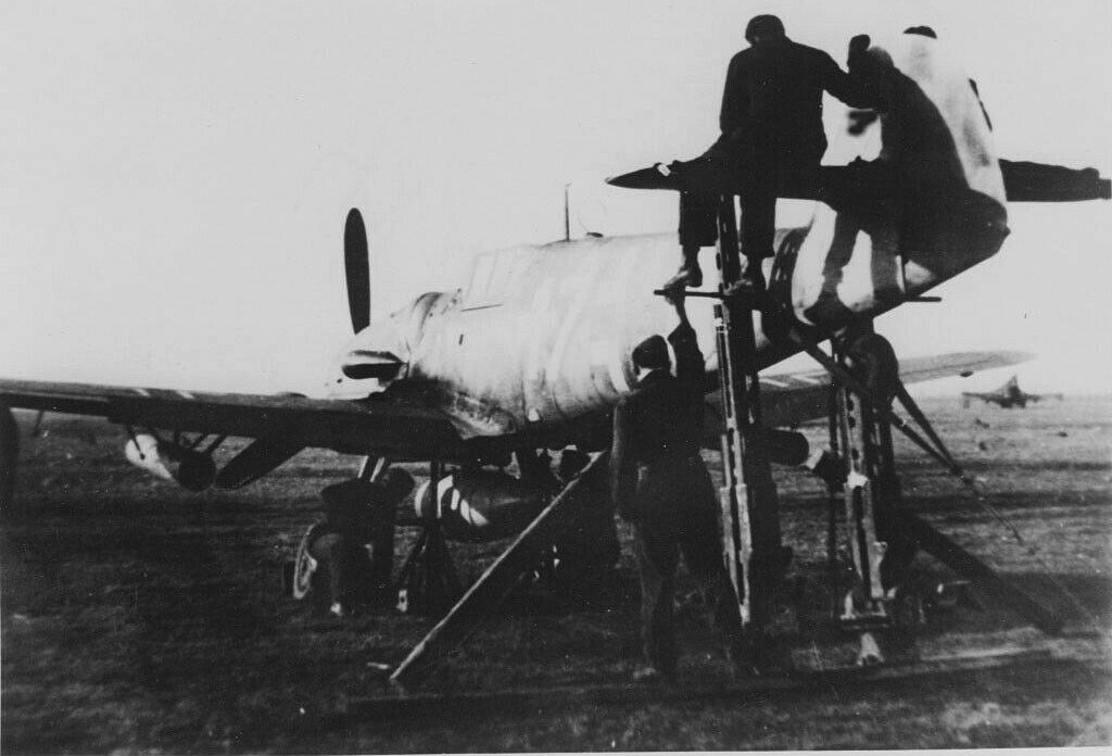 Bf 109 G-6/W/R3, Jagdgeschwader 53, III. Gruppe, 7. Staffel, Deutschland, weisse 17, Villaorba (Italien), Justieren der Bordwaffen.

Das Hakenkreuz wurde auf dem Scan weg retuschiert.