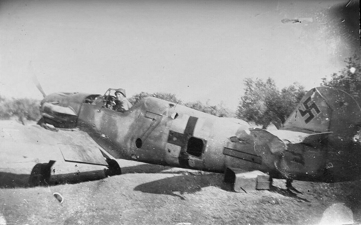 Bf 109 G-4 trop, Jagdgeschwader 53, II. Gruppe, 6. Staffel, Deutschland, gelbe 7, W.Nr. 16 304, La Marsa (Tunesien), Ein alliierter Soldat posiert auf einer Beutemaschine.

Die Angaben zur Gru…