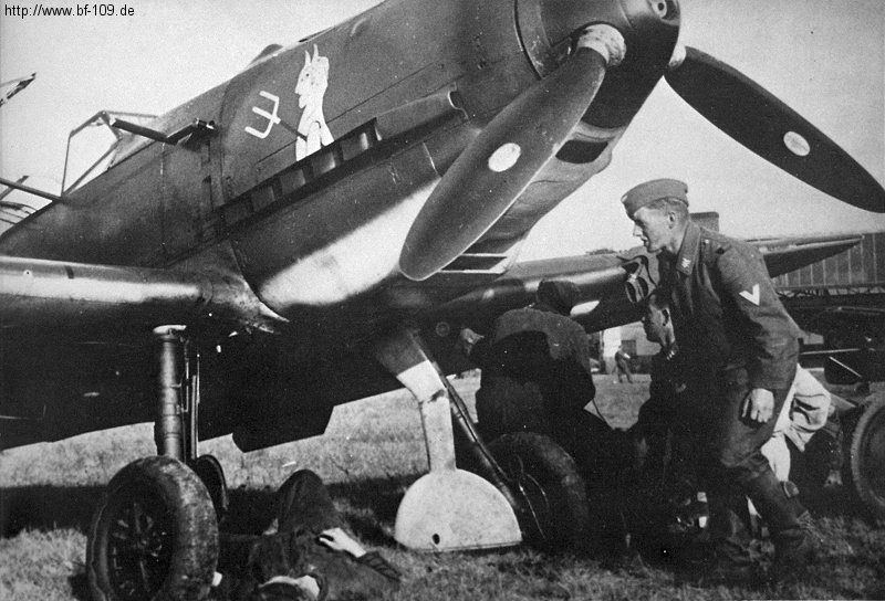 Bf 109 E-3, Lehrgeschwader 2, I. (J) Gruppe, Deutschland, Wartung am Fahrwerk. Auf der Motorhaube befindet sich ein persönliches Abzeic…