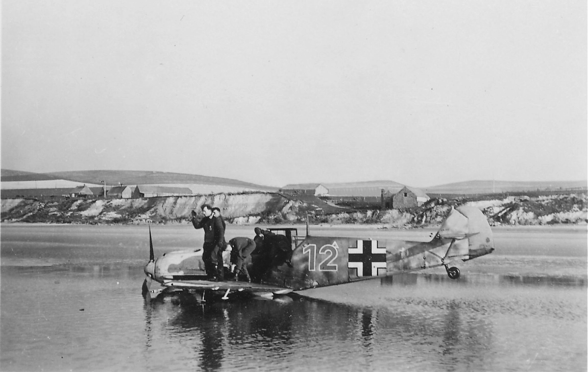 Bf 109 E, Lehrgeschwader 2, I. (J) Gruppe, 3. Staffel, Deutschland, braune 12, Bauchlandung an der Kanalküste.

Das Hakenkreuz wurde auf dem Scan weg retu…