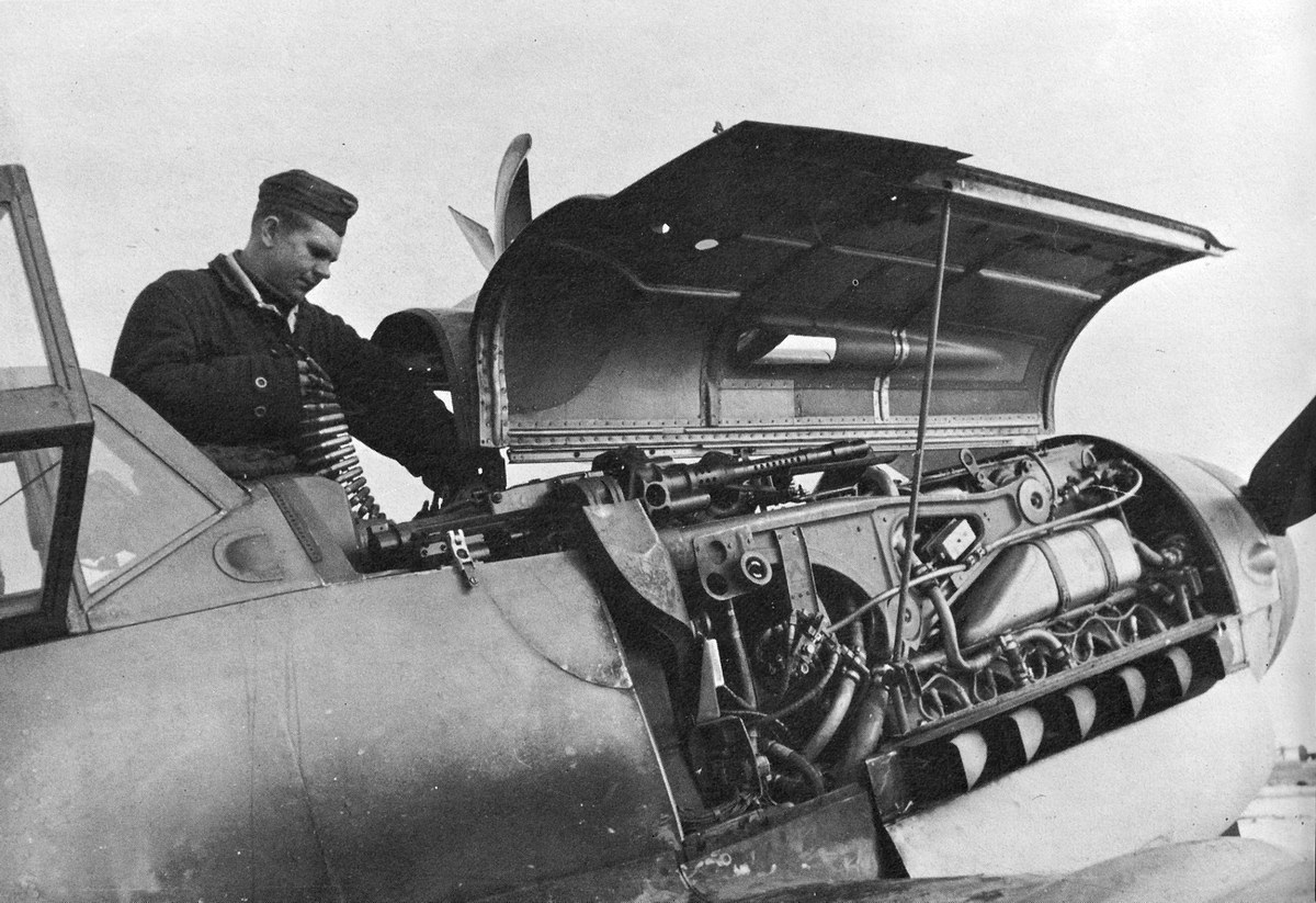 Bf 109 G-6, Jagdgeschwader 3, III. Gruppe, Deutschland, Leipheim (Deutschland), Der Waffenwart munitioniert die MG 131 auf. Gut zu sehen die Gurtzuführung zu…