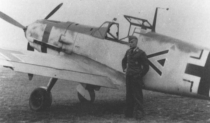 Bf 109 E-4, Hptm. Günther von Maltzahn, Jagdgeschwader 53, Stab, Deutschland, Winkel Dreieck, Um die Motorhaube wurde ein rotes Band lackiert.

Vor der Maschine steht Lt…