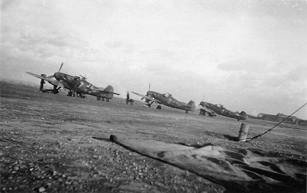 Bf 109 G-6, Jagdgeschwader 300, I. Gruppe, 1. Staffel, Deutschland, weisse 7, Von links: "weisse 7", "weisse 2" und "weisse 1" mit dem Geschwaderabzeichen …