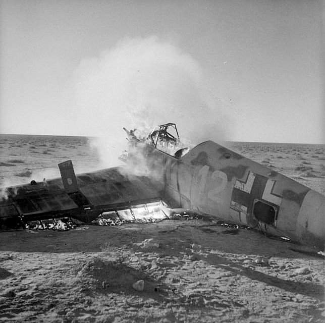 Bf 109 E-7/Trop, Jagdgeschwader 27, I. Gruppe, 1. Staffel, Deutschland, weisse 12, Propaganda-Foto von Alliierten Truppen, welche diese Beutemaschine abgefackel…